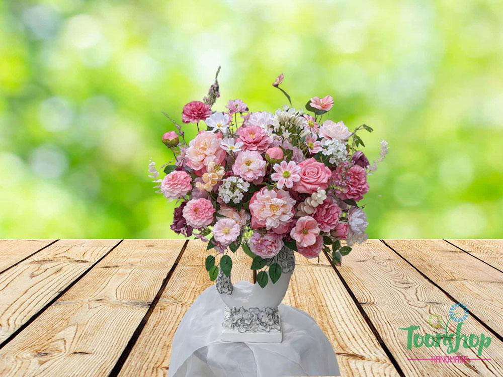 Bình hoa lụa hạnh phúc đong đầy được bầy trên bàn