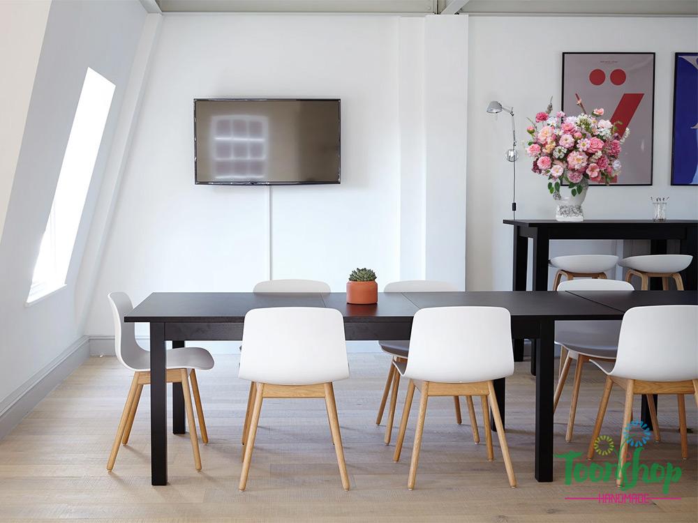Bình hoa lụa hạnh phúc đong đầy đặt trên kệ phòng họp công ty