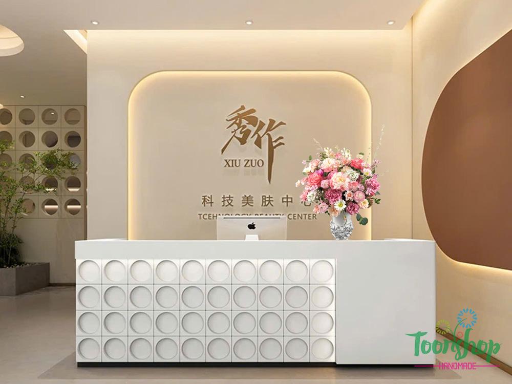 Bình hoa lụa tone hồng kiêu sa bầy trên bàn lễ tân công ty
