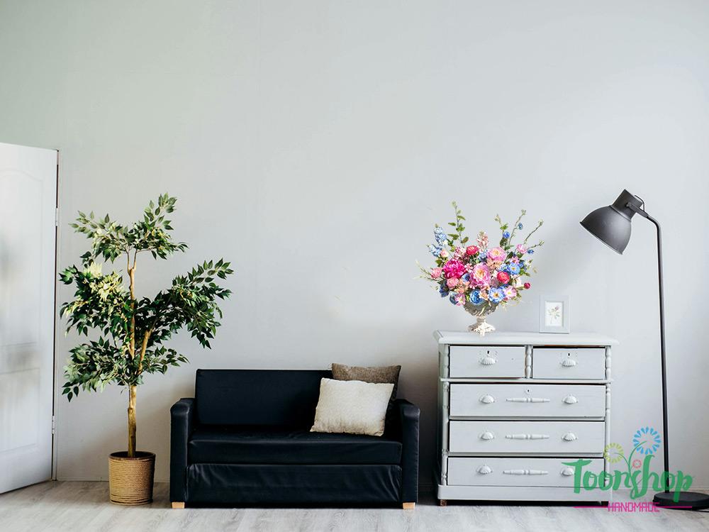 Bình hoa lụa được bầy trên tủ kệ cạnh sofa