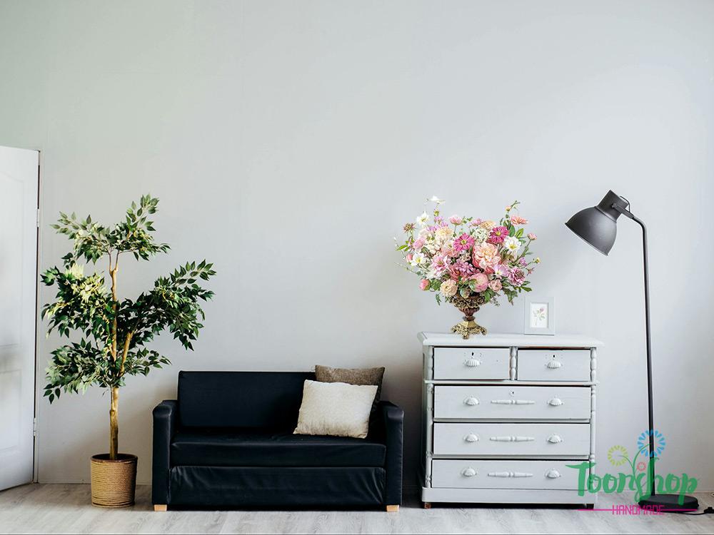 Bình hoa lụa hồng lãng mạn đặt trên kệ phòng đọc sách