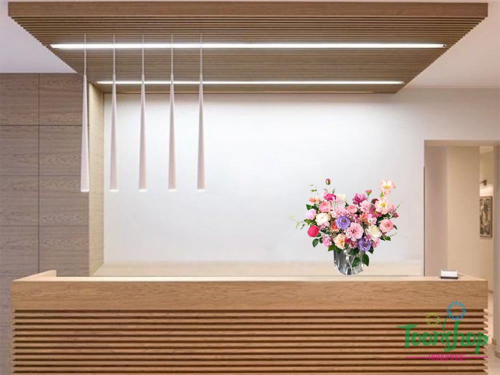 Giỏ hoa lụa để bàn được đặt tại quầy lễ tân sảnh chung cư